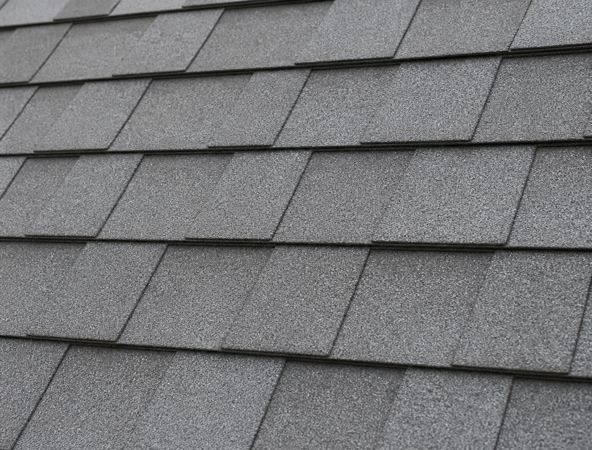 Close-up of new grey architectural shingles installed in neat rows